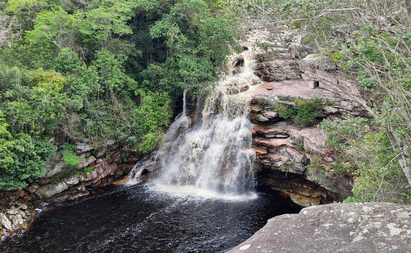 Turista mergulhando nas águas escuras e profundas do Poço do Diabo na Chapada